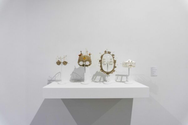 Objects made of cardboard on a shelf in a white cube
