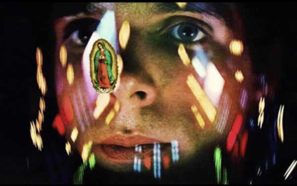 Primer plano del rostro de un hombre. Sobre él parece haber una superficie transparente que refleja luces de distintos colores y la imagen de la Virgen de Guadalupe.