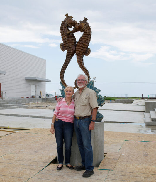 Veerle and Kent Ullberg stand in front of "Merry Time Romance" by Mr. Ullberg. The 8-foot tall sculpture features a pair of seahorses.