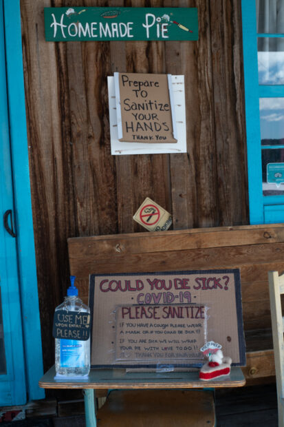 Photo of ephemera and hand written signs entering a local business