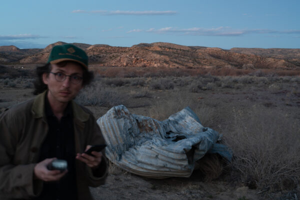 Photo of the author walked away from detritus on the side of the road in a desert landscape