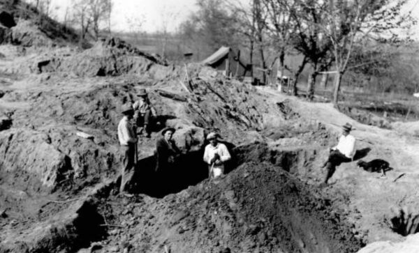 Historical photo of workers digging in a mound