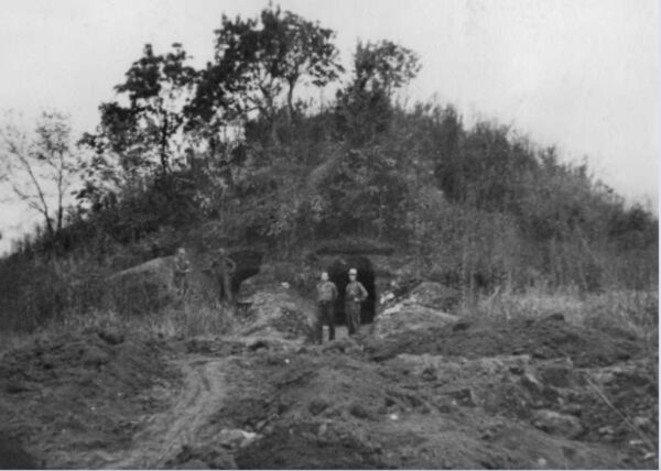 Entrance to tunnels at Spiro with two workers in front