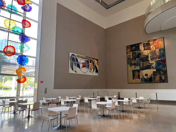 A photograph of the Dallas Museum of Art atrium featuring "Hart Window" by Dale Chihuly, "Paper Clip" by James Rosenquist, and "Skyway" by Robert Rauschenburg.