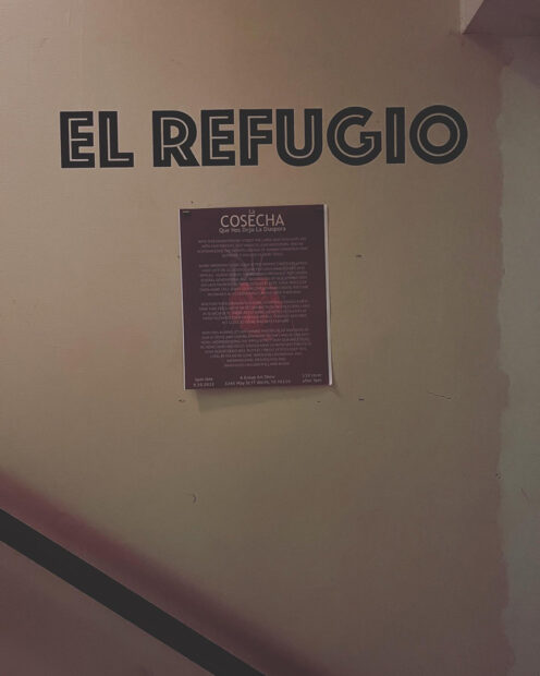 A photograph of wall text that reads, "El Refugio." Below the text is a poster for the exhibition "La Cosecha Que Nos Dejó La Diáspora (The Harvest that the Diaspora Left Us)."