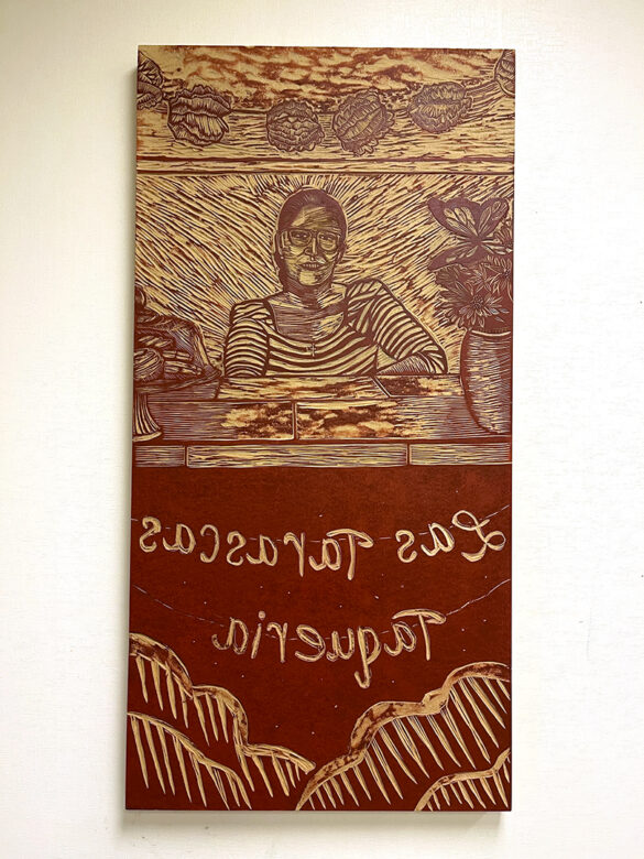 A photograph of a relief carving by Ángel Faz of a woman seated behind a booth.