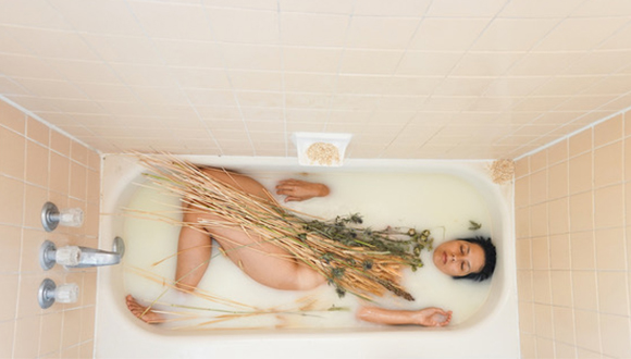 Photo of the artist in a bath of her own breast milk