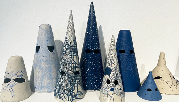 Conical ceramic forms in various shades of blue, white, and gray