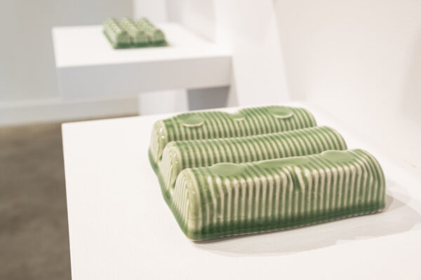 Green ceramic packing objects on a white shelf