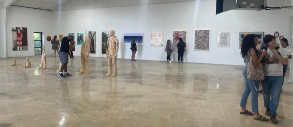 A photograph of visitors looking at artworks on display at Ro2 Art.