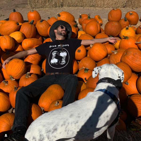 A man and his dog in a pumpkin patch