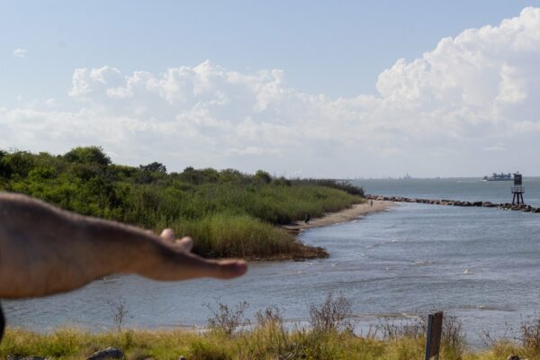 A hand is outstretched over the Galveston East Bay