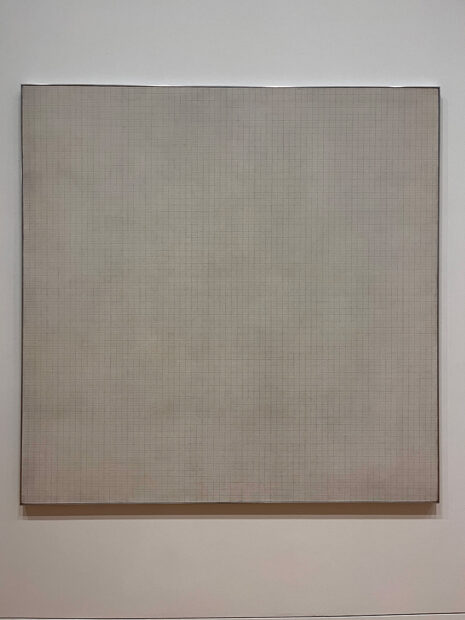 A large square shaped canvas painted by Agnes Martin featuring thousands of tiny rectangles created by meticulously drawn horizontal and vertical lines.