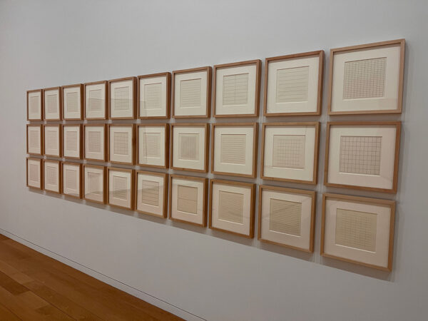 An installation image of 30 framed silkscreen prints by Agnes Martin.