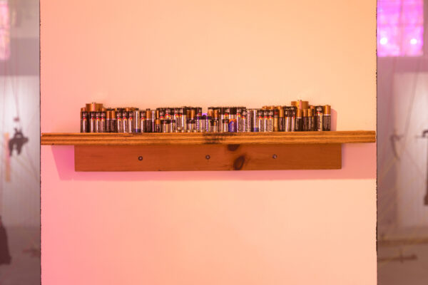 multiple batteries on a shelf in a gallery