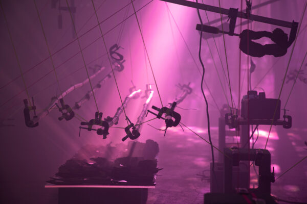 Installation view of mechanical parts in hazy purple light