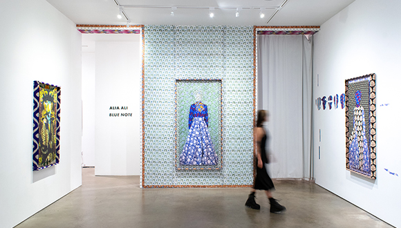 Installation view of a woman walking through an exhibition