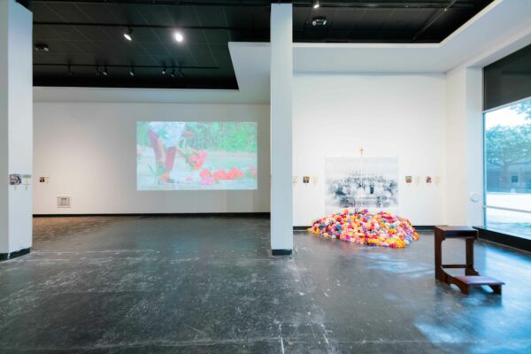 Installation view of two dimensional work on the walls, a video projection, and sculpture in a space