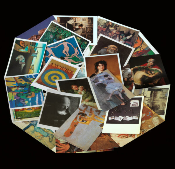 A photograph of postcards featuring artworks, which have been arranged in a mandala shape on a black background.
