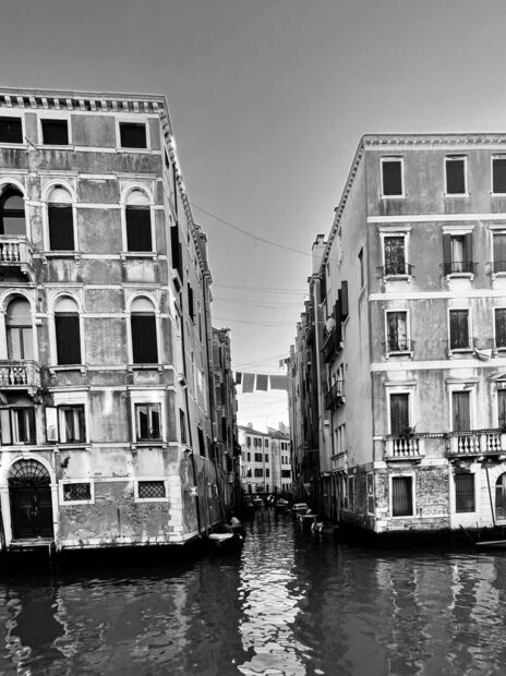 Black and white image of leaning buildings in Venice