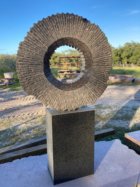 A granite sculpture by Jesús Moroles of an abstract moon sitting on a pedestal.