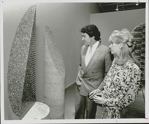 A photograph of Museum of Fine Arts director Peter Marzio and his wife Frances Marzio looking at a Jesús Moroles sculpture.