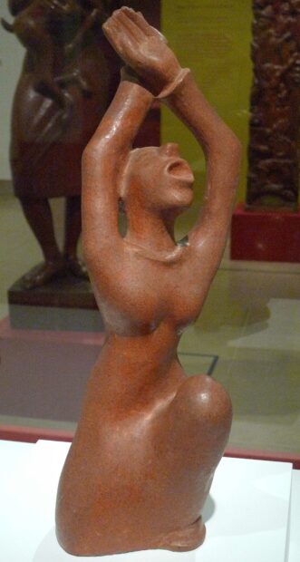 Terra cotta sculpture of a woman with her hands raised