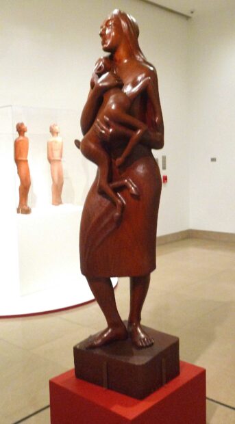Sculpture of a standing woman holding a deer