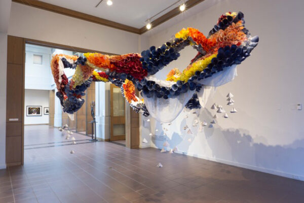 installation view of a floating, multi-colored piece suspended in the space