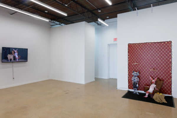 Installation view of two puppets and a video