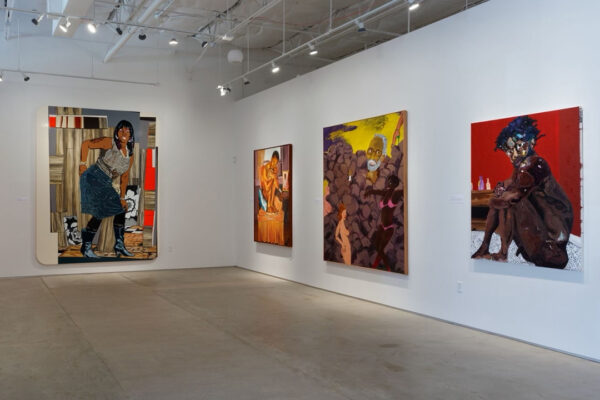 An installation image of a gallery with a handful of large paintings. The works are difficult to see since the lighting has not been adjusted for the exhibition.