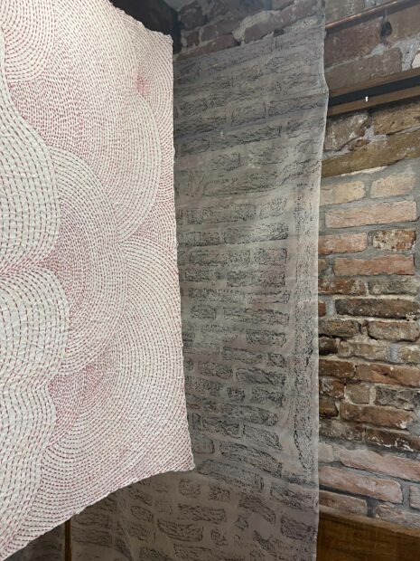Fabric hanging in front of a brick wall