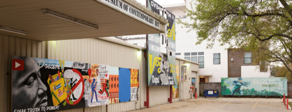 A photograph of temporary murals posted against the exterior wall of the Station Museum in Houston.
