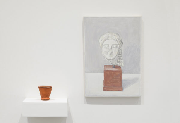 Installation of a painting on a wall on the right and a ceramic cup on a shelf on the left