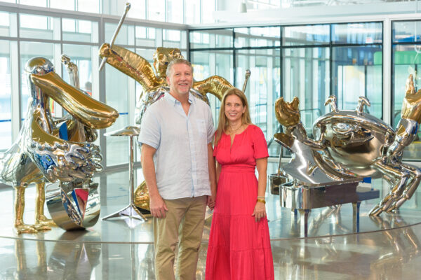 Artists Brad Oldham and Christy Coltrin stand in front of their large metal sculpture "Galveston Beach Trio."