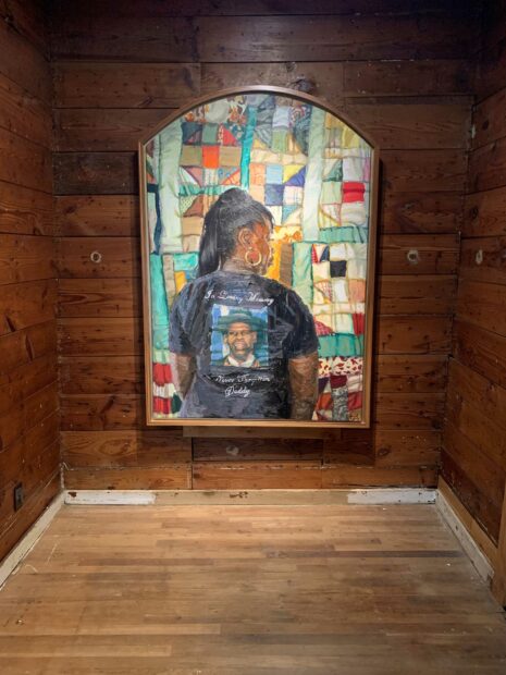 Installation view of a painting on a wood wall