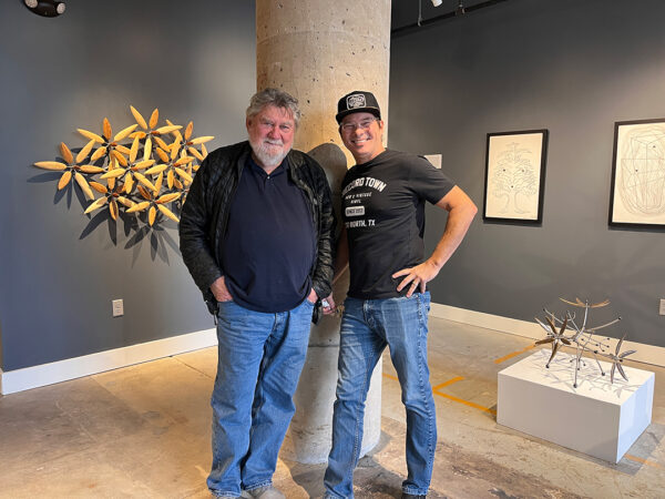 The artist James Surls stands next to gallery owner Bale Creek Allen with work by Surls in the space behind them.