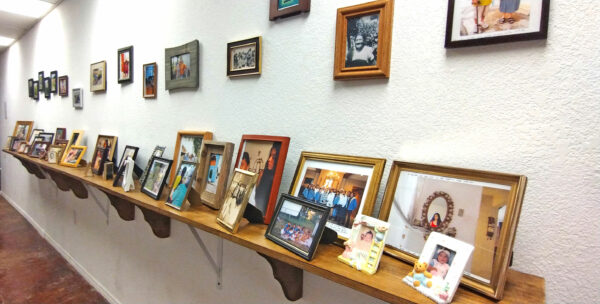 Personal and family photos on a shelf and on the wall