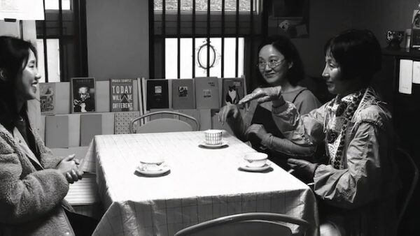 Image of three women siting at a table drinking tea