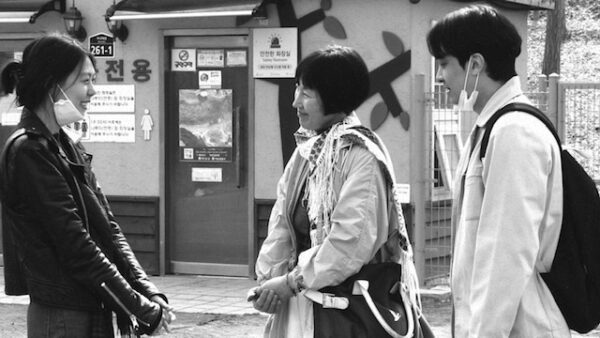 Black and white still of three actors talking
