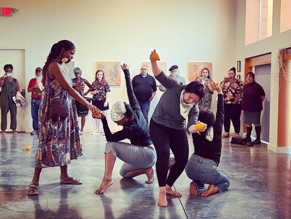A photograph of four women mid-performance in a gallery.
