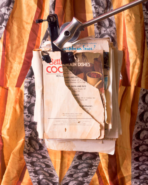 Photo of antique cookbooks in front of an orange fabric backdrop