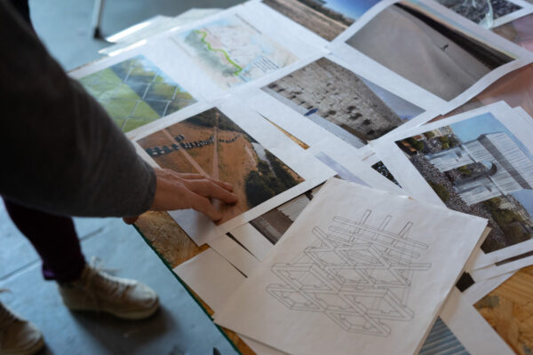 A photograph of Antonio Lechuga’s work table covered with reference photos of walls.