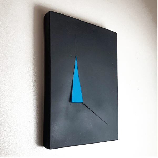 A black wallhanging ceramic sculpture with a blue triangle in the center.