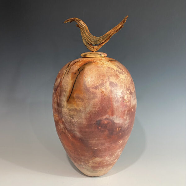 A large, brown ceramic vase-like sculpture, with a large, organic form on the top.