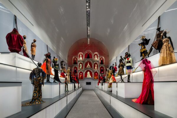 An photograph of a dramatic installation of couture dresses by Dior on view at the Dallas Museum of Art. 