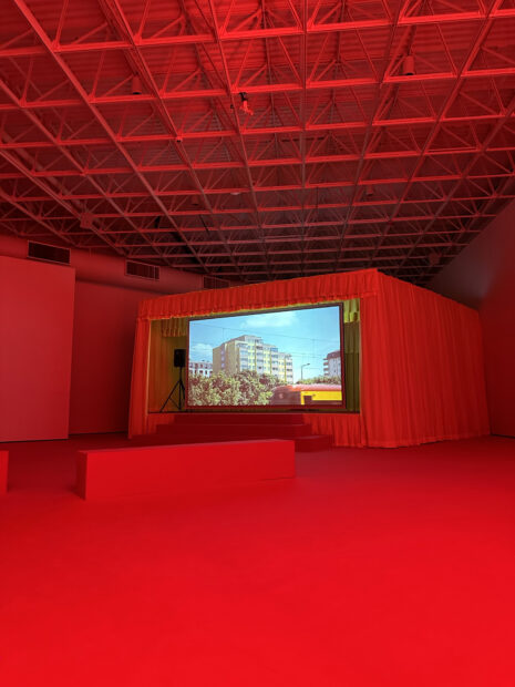 A red theater room with a projection of a building