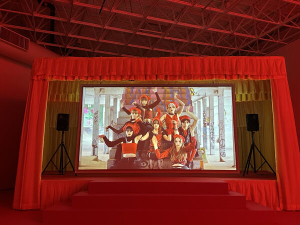 Video projection installation of dancers in a red theater