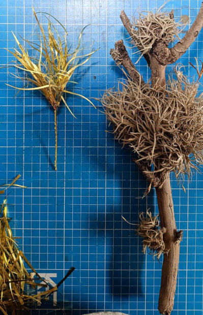Image of brass replicas of ball moss next to original ball moss