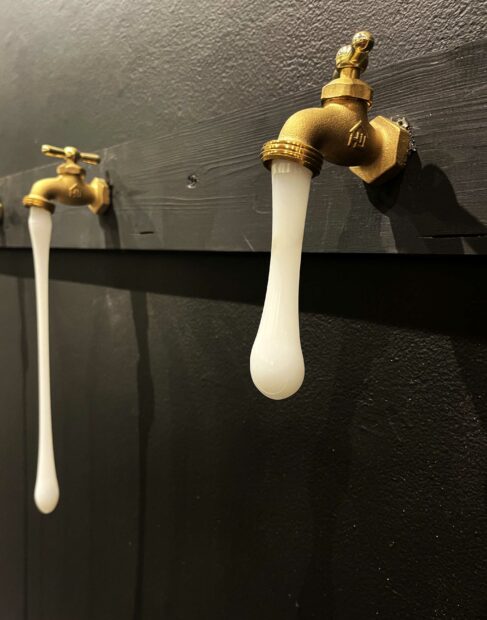 Detail of a white glass drip from a water spigot